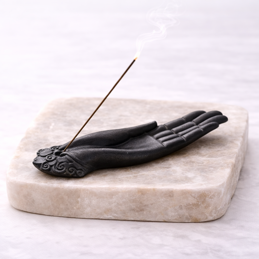 Buddha hand incense holder with incense stick on beige stone slab