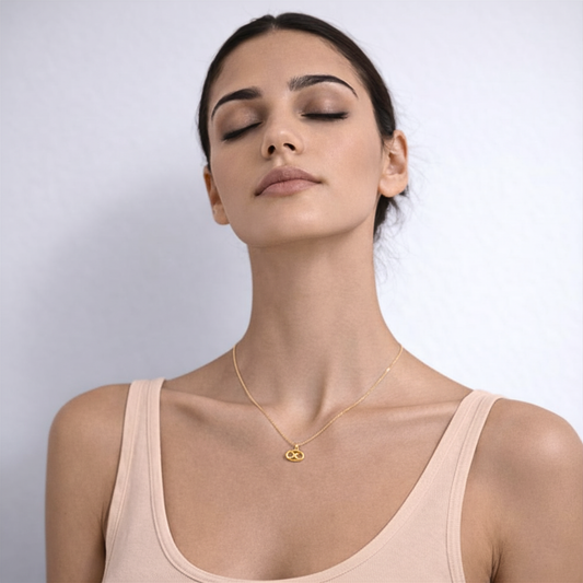 Cancer zodiac necklace gold close up on model showing pendant on chest