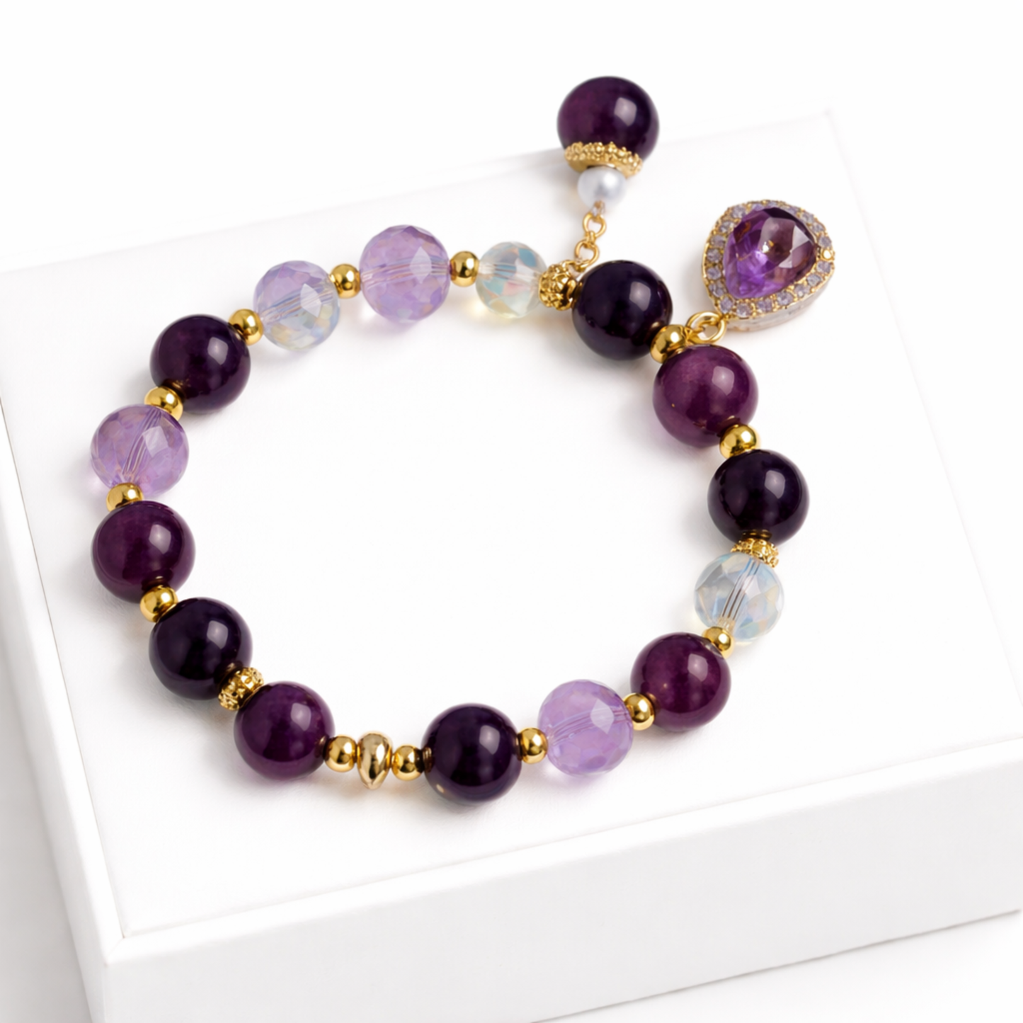 Purple amethyst gemstone bracelet with gold bead spacers and crystal beads on white background
