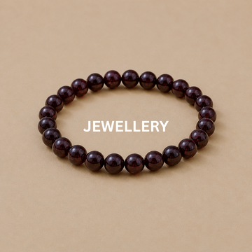 Garnet crystal bracelet on beige stone slab jewellery display