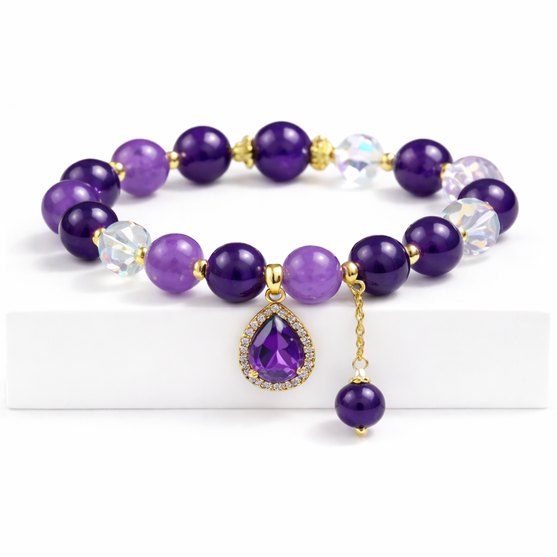 Amethyst beaded bracelet with gold spacers and purple pendant charm jewellery close up