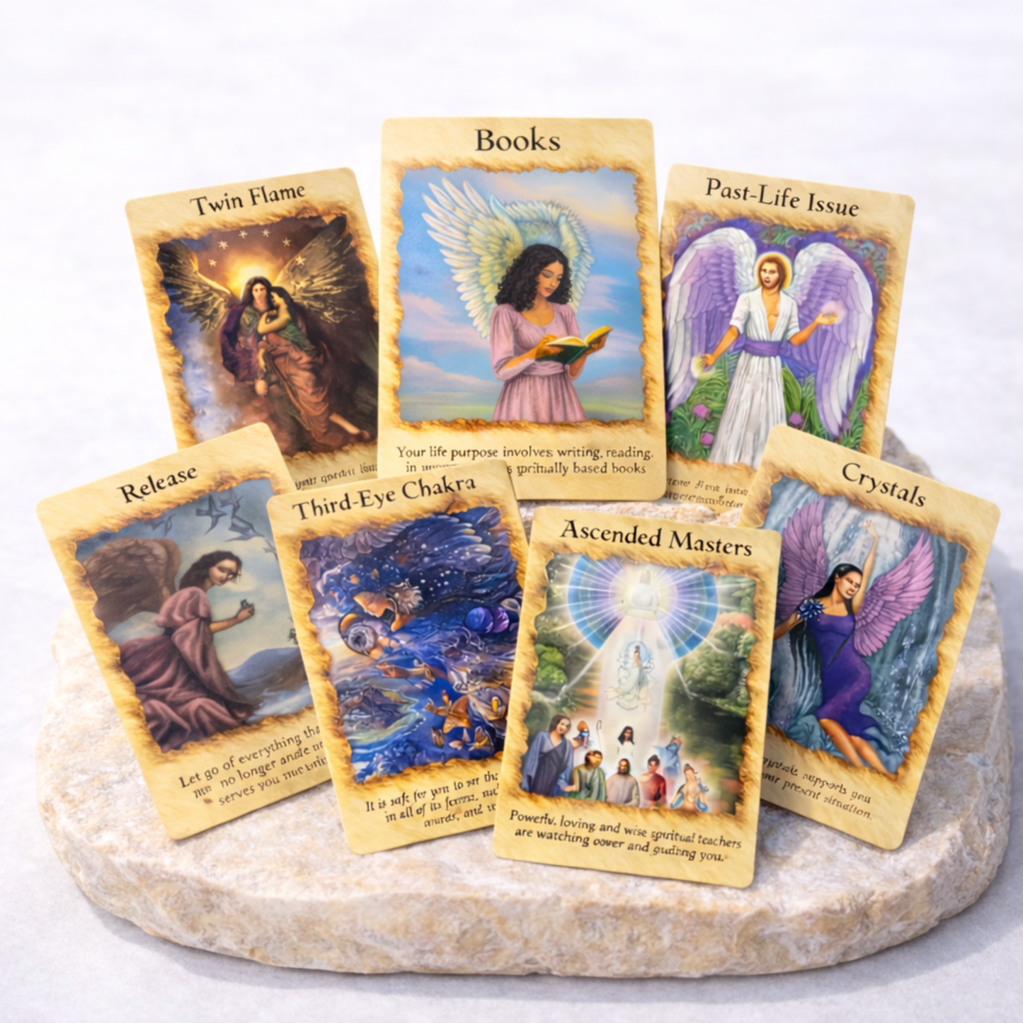 Angel oracle cards spread showing multiple illustrated cards on beige stone slab