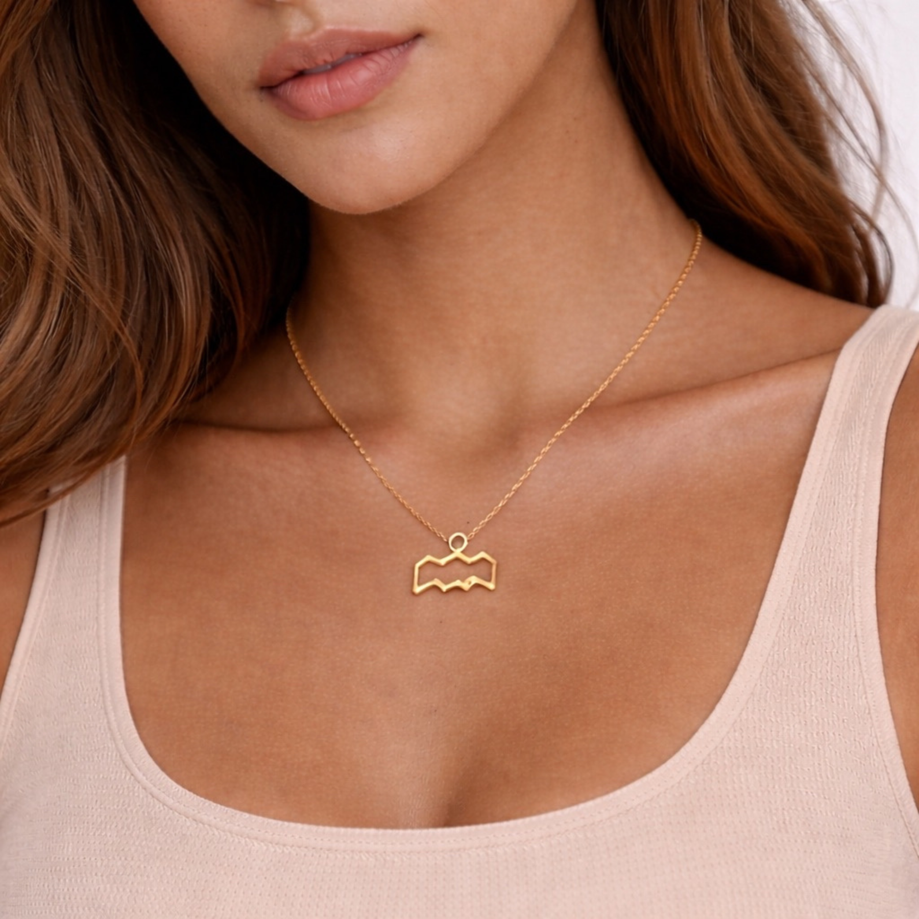 Aquarius gold plated necklace close up on model showing gold pendant on chest
