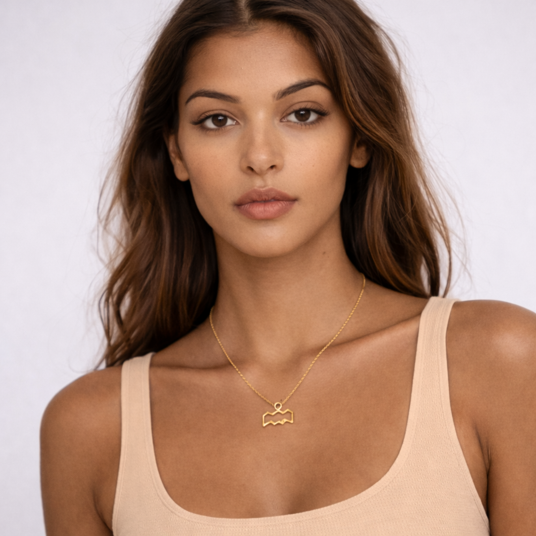 Aquarius gold plated necklace worn on model front view with beige top