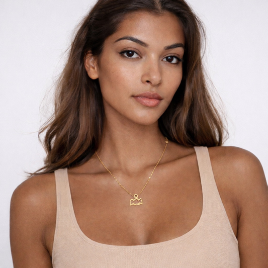 Aquarius gold plated necklace worn on model with beige top and gold chain