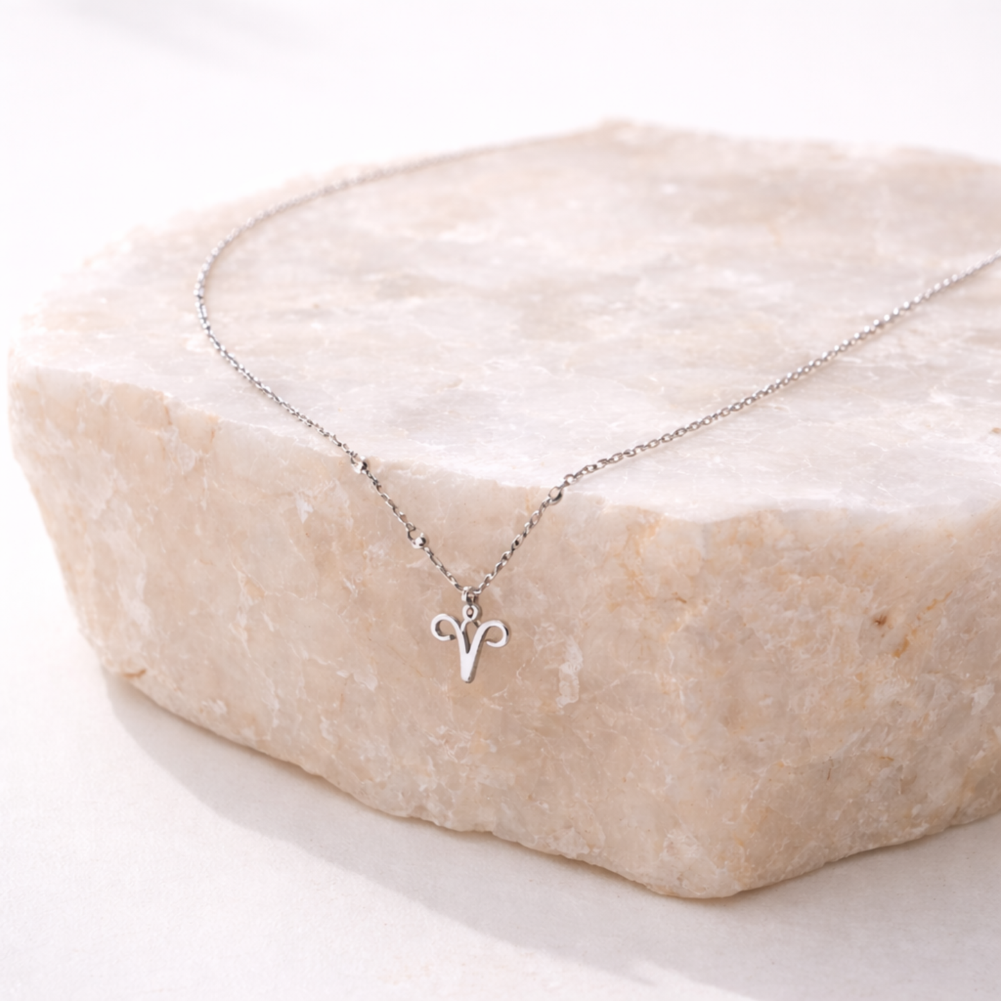 Aries necklace silver zodiac symbol pendant on beige stone slab