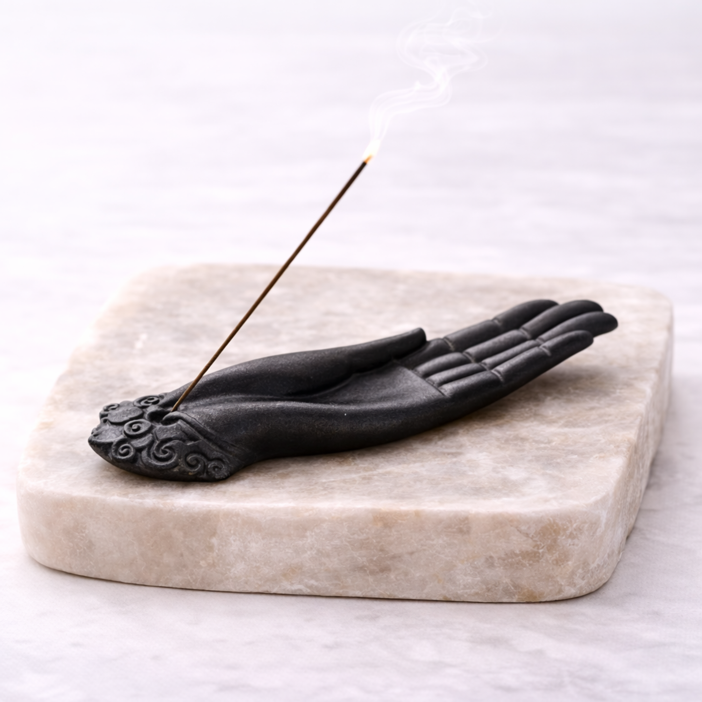Buddha hand incense holder with incense stick on beige stone slab