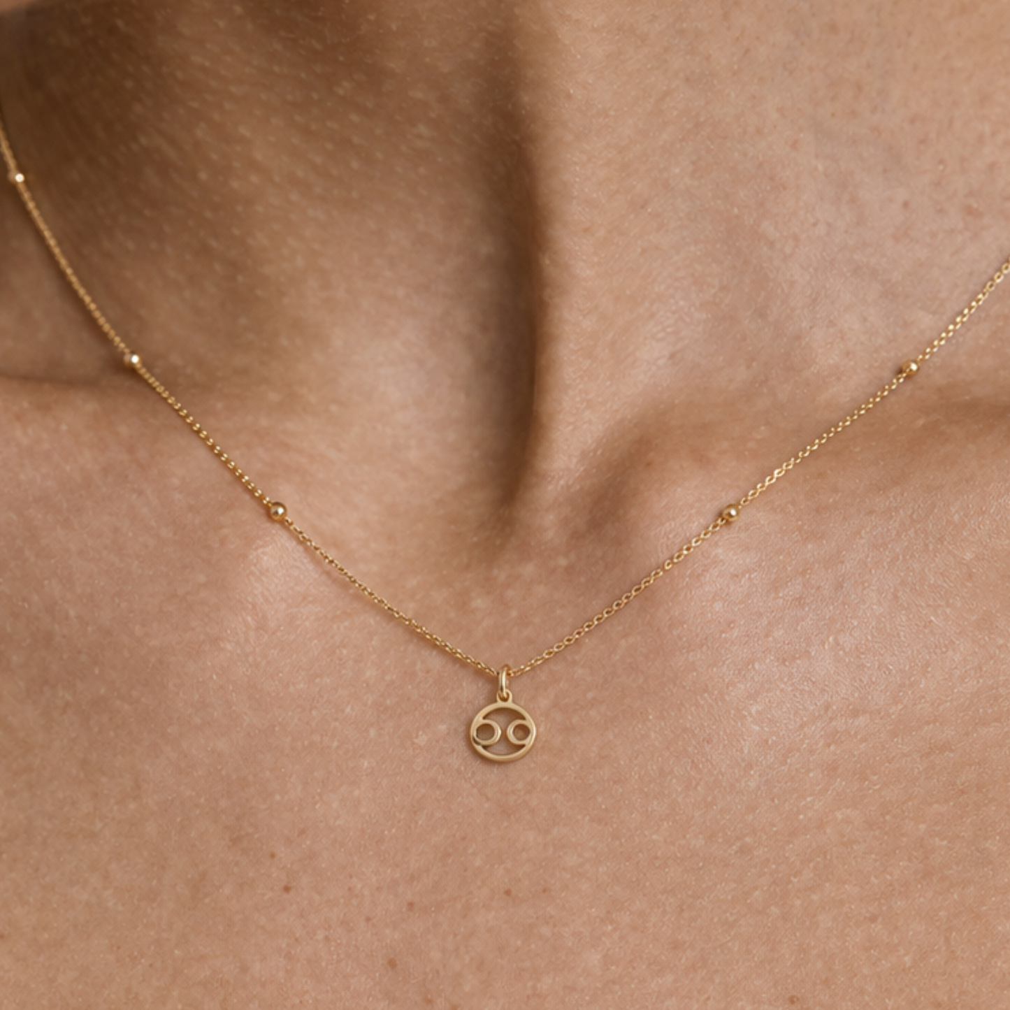 Cancer zodiac necklace gold close up showing zodiac symbol pendant