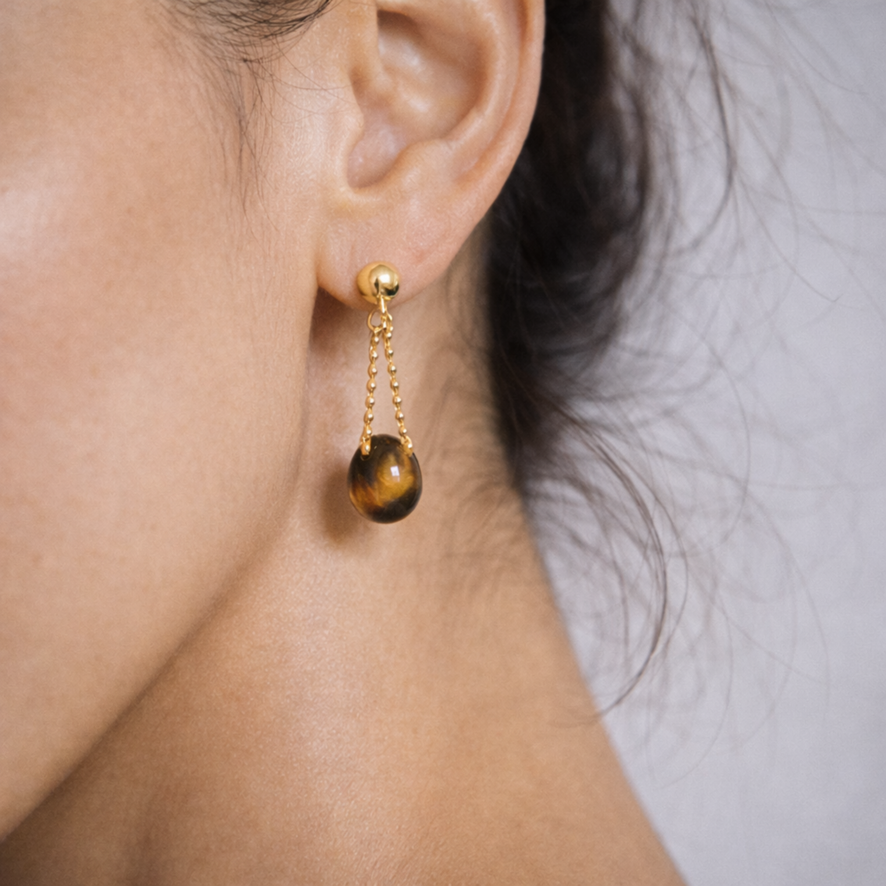 Close up of Tiger’s Eye earrings on ear