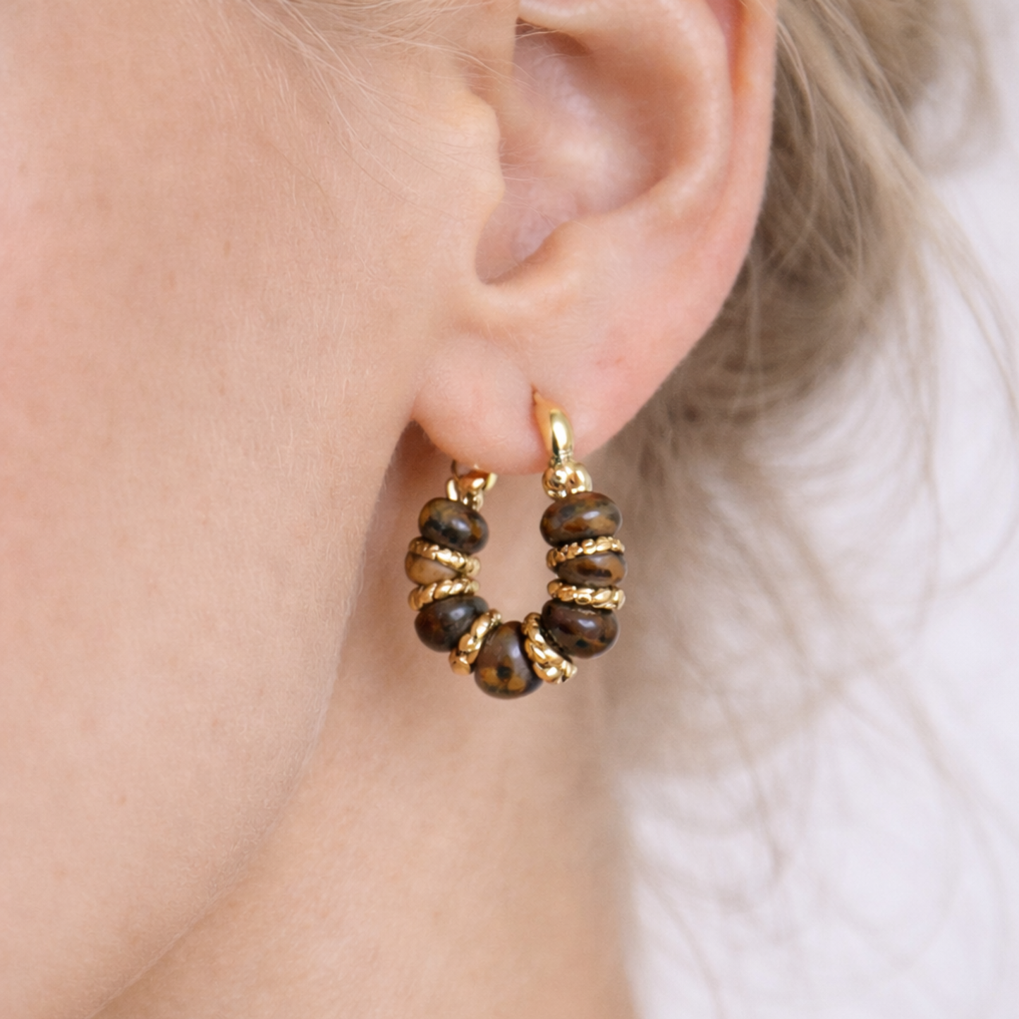 Close up of Tiger’s Eye hoop earring on ear