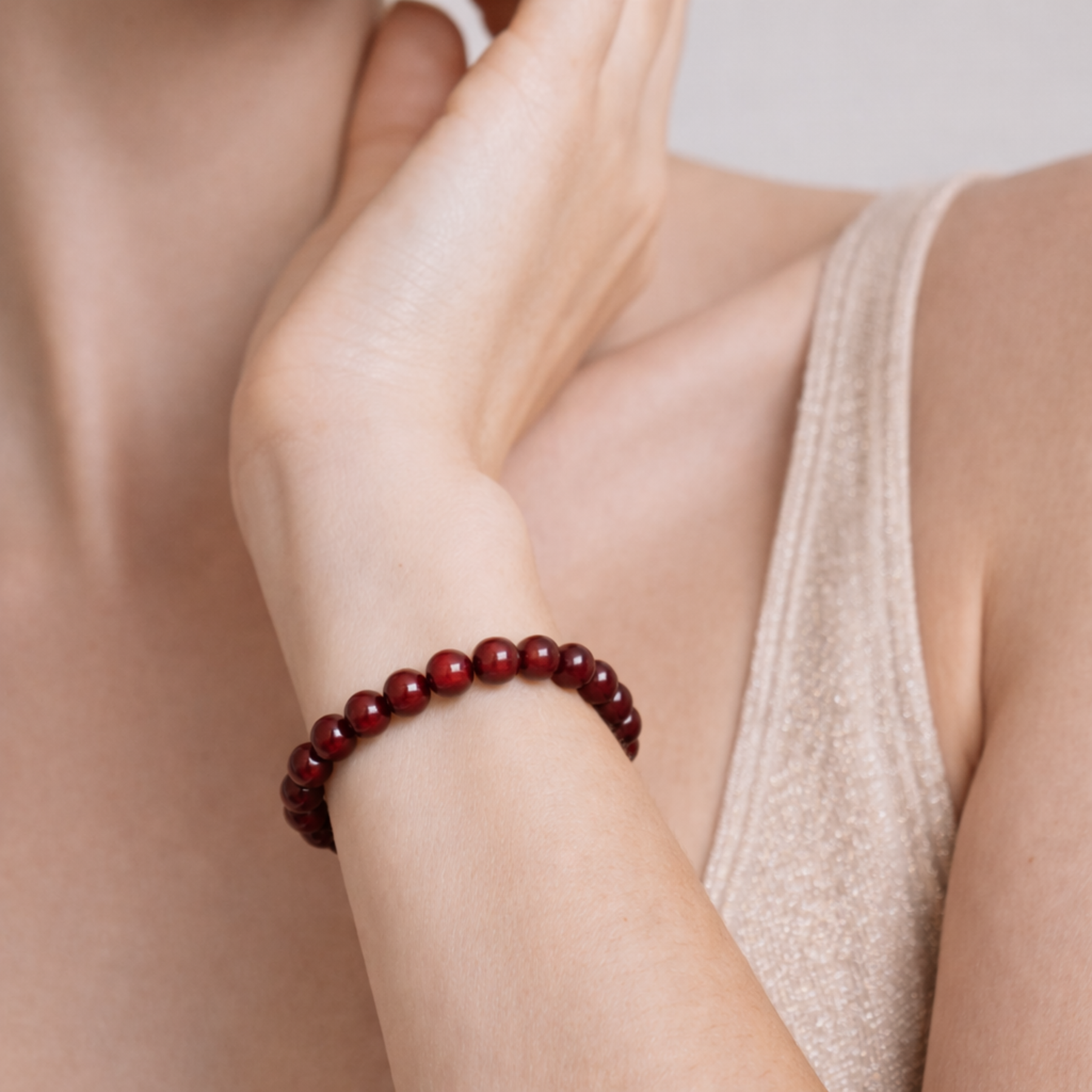 Close up of cinnabar bead bracelet on wrist showing deep red crystal beads