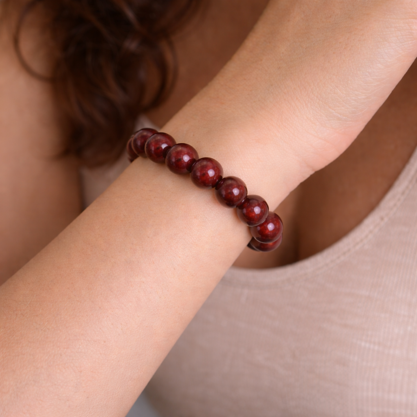 Close up of cinnabar crystal bead bracelet on wrist