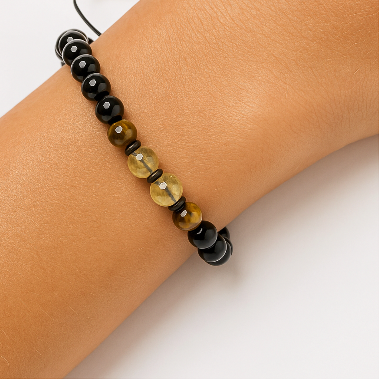Close up of citrine crystal and tiger’s eye bracelet with black beads on wrist