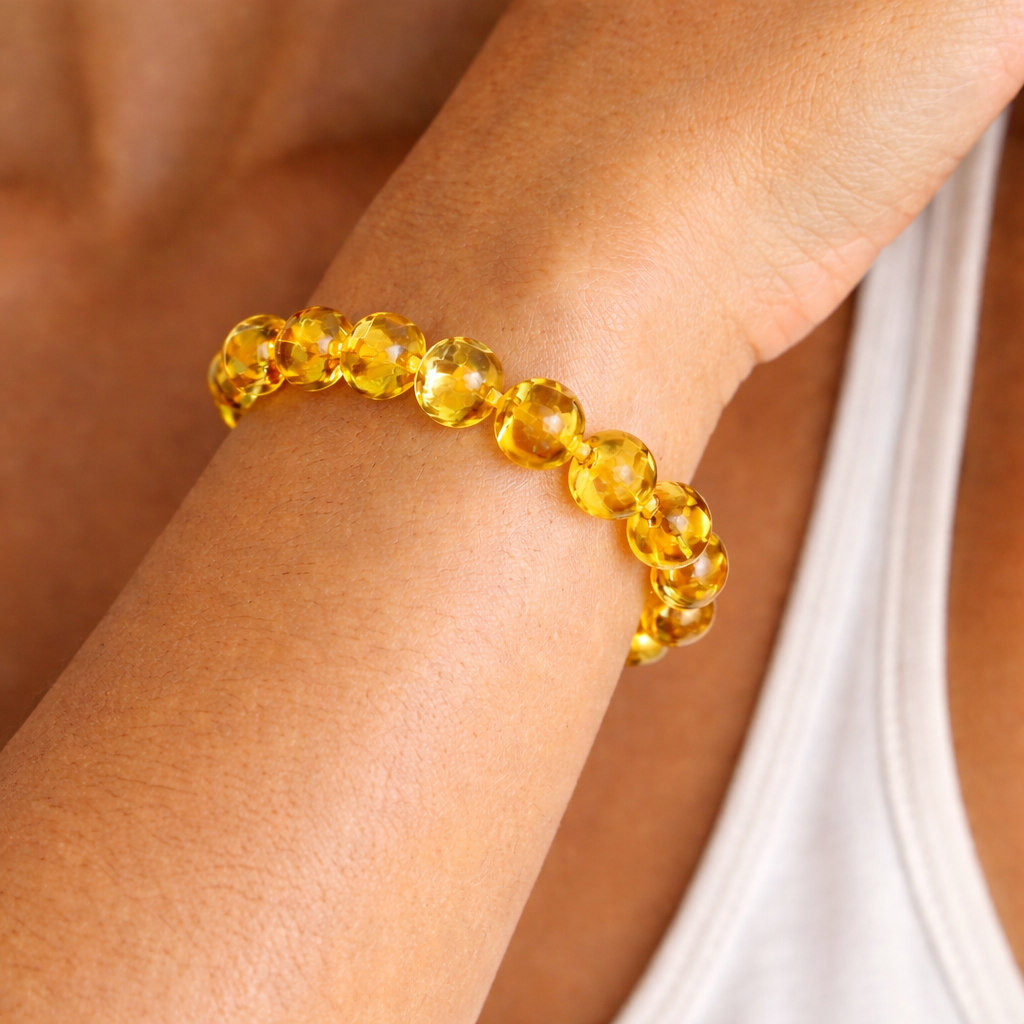 Close up of citrine crystal bracelet worn on wrist with polished yellow gemstone beads