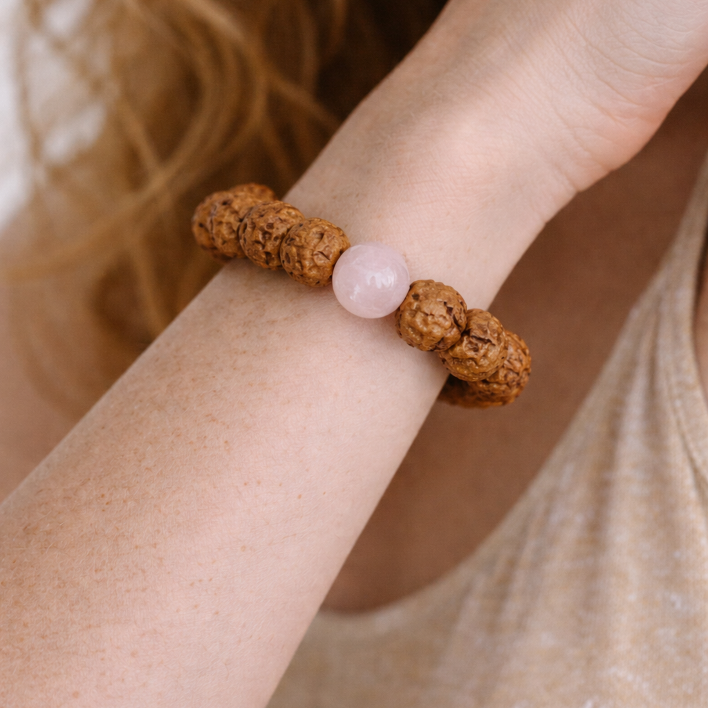 Close up of rudraksha and rose quartz bracelet worn on wrist