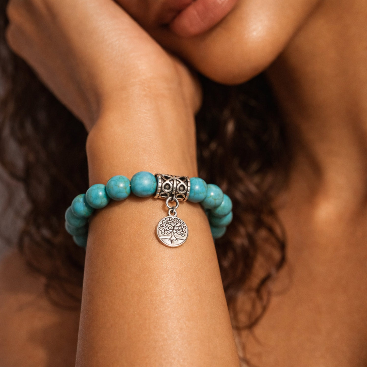 Close up of turquoise crystal bracelet with tree of life charm worn on wrist