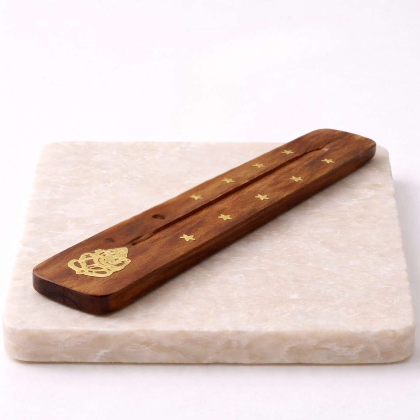 Ganesh incense holder with incense stick on beige slab side angle