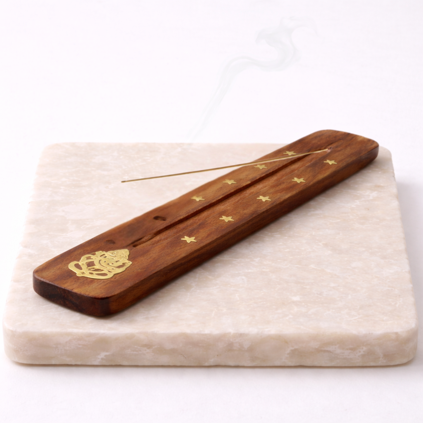 Ganesh incense holder with incense stick on beige stone slab natural wood