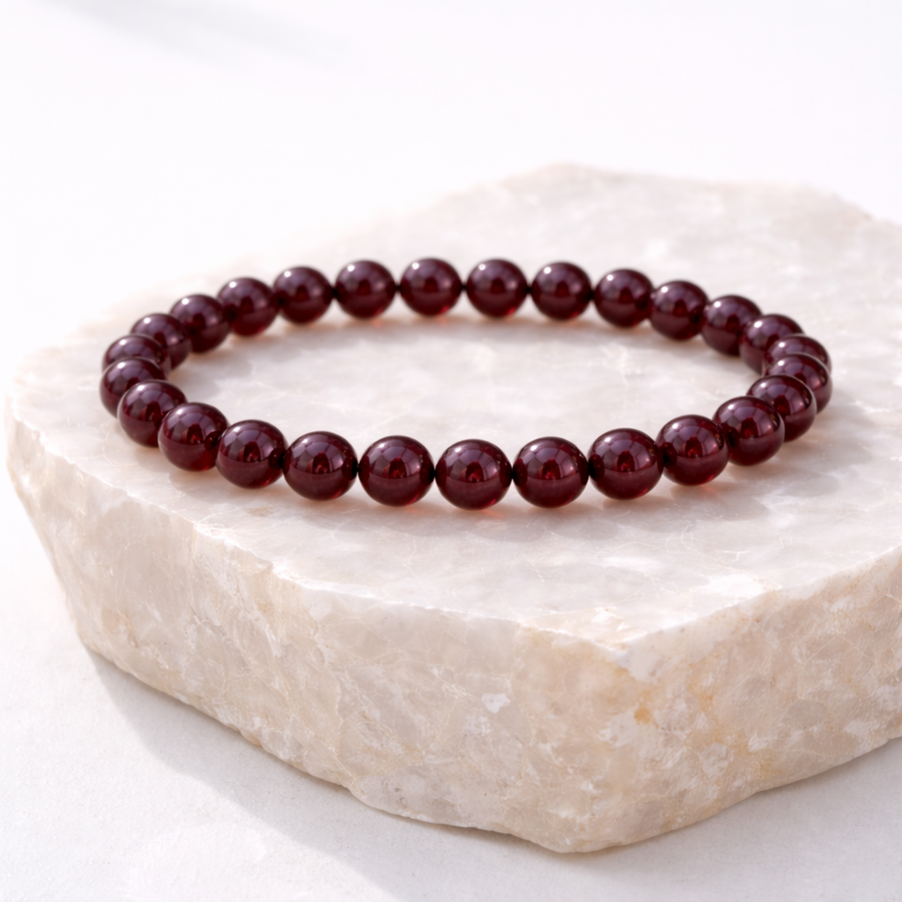 Garnet crystal bead bracelet on marble display stone