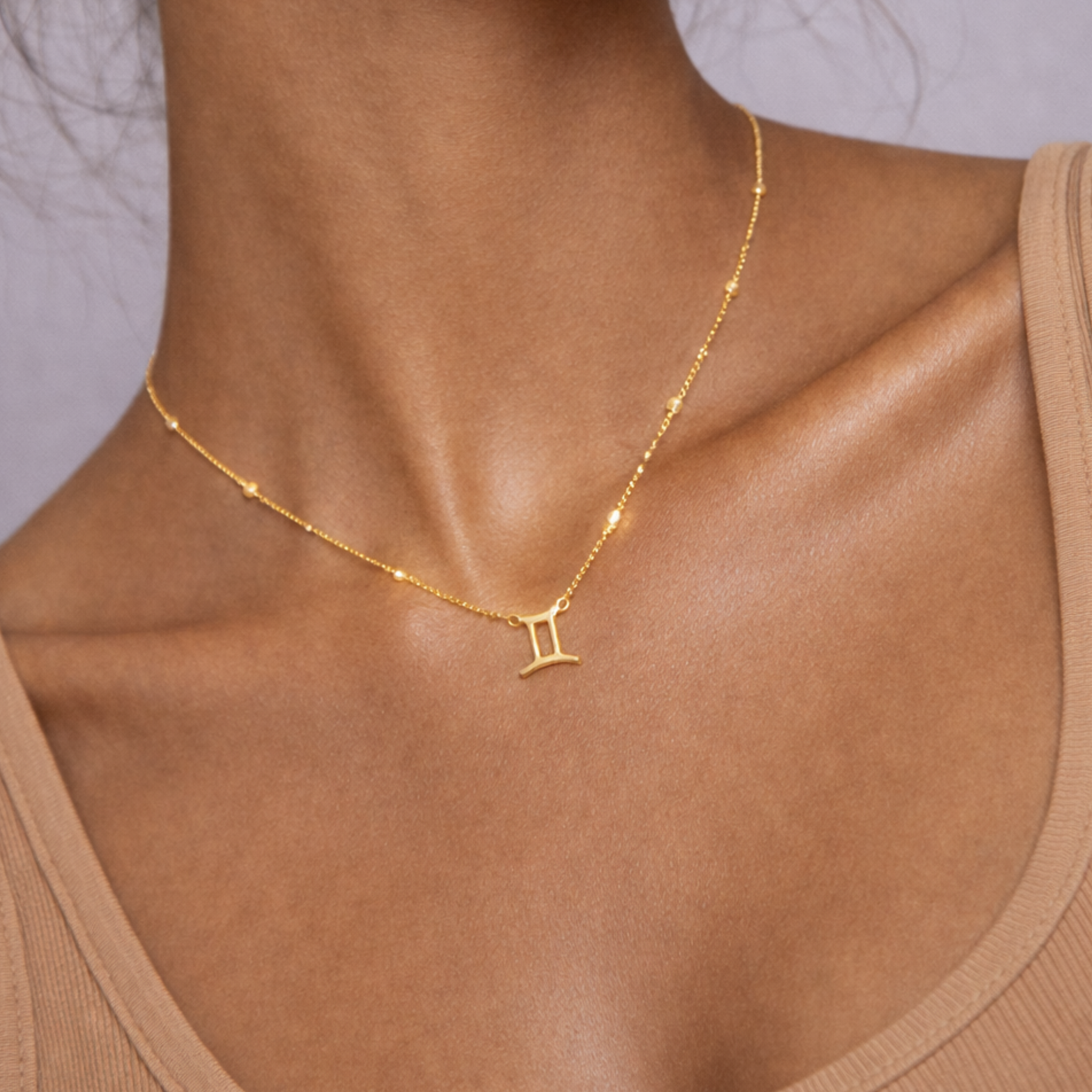 Gemini zodiac necklace gold close up showing zodiac symbol pendant