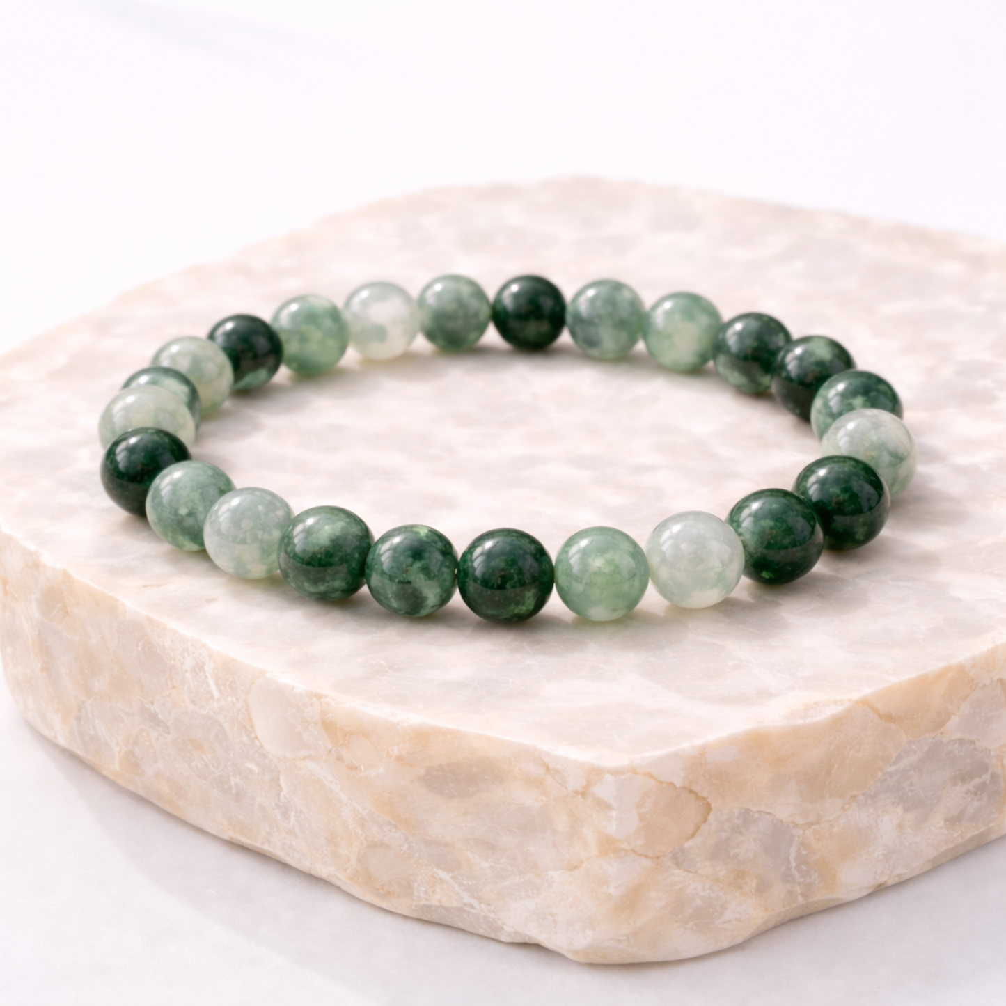 Jadeite crystal bead bracelet on natural stone display