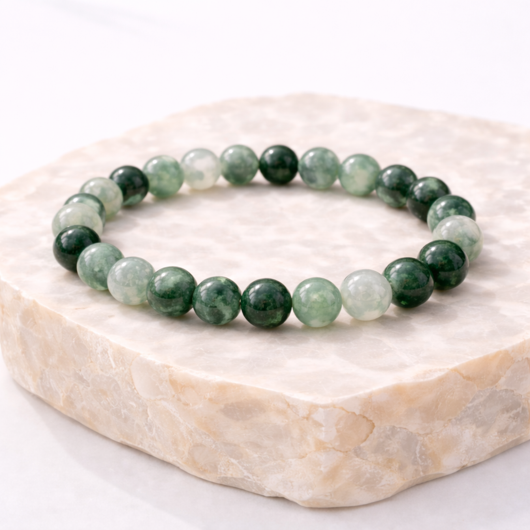 Jadeite crystal bead bracelet on natural stone display
