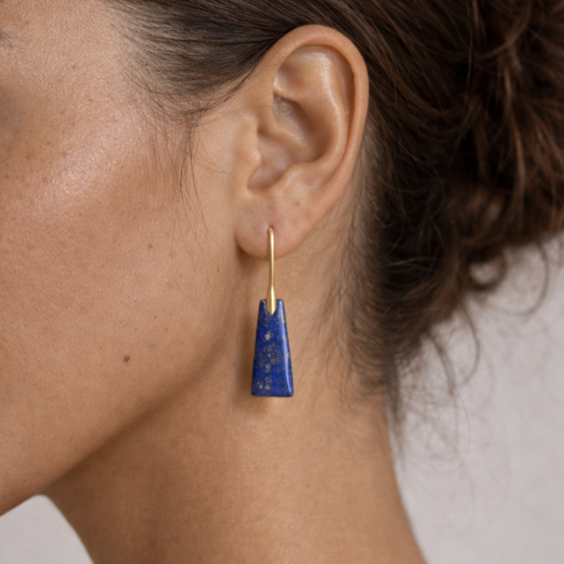 Lapis lazuli cut stone earrings close up on ear