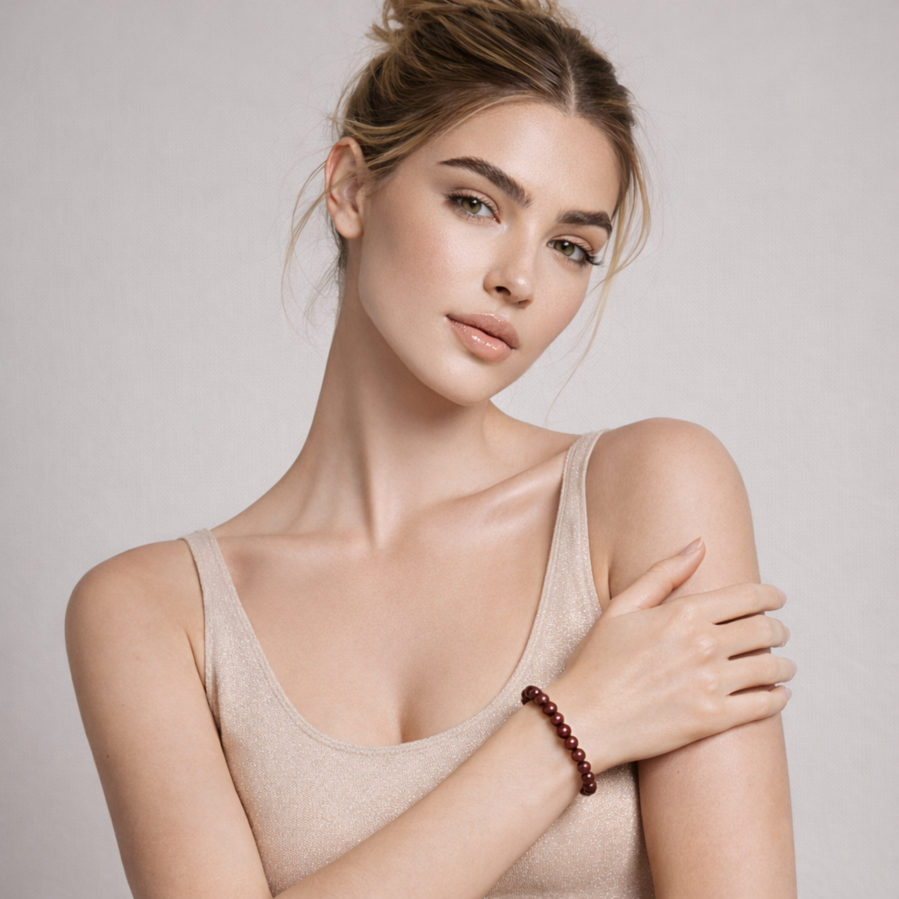 Model wearing cinnabar crystal bead bracelet with deep red polished stones