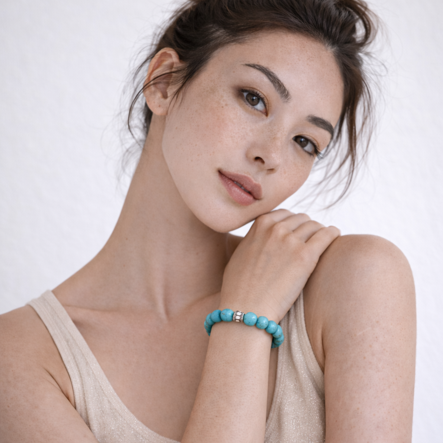 Model wearing turquoise bead bracelet with silver spacer beads