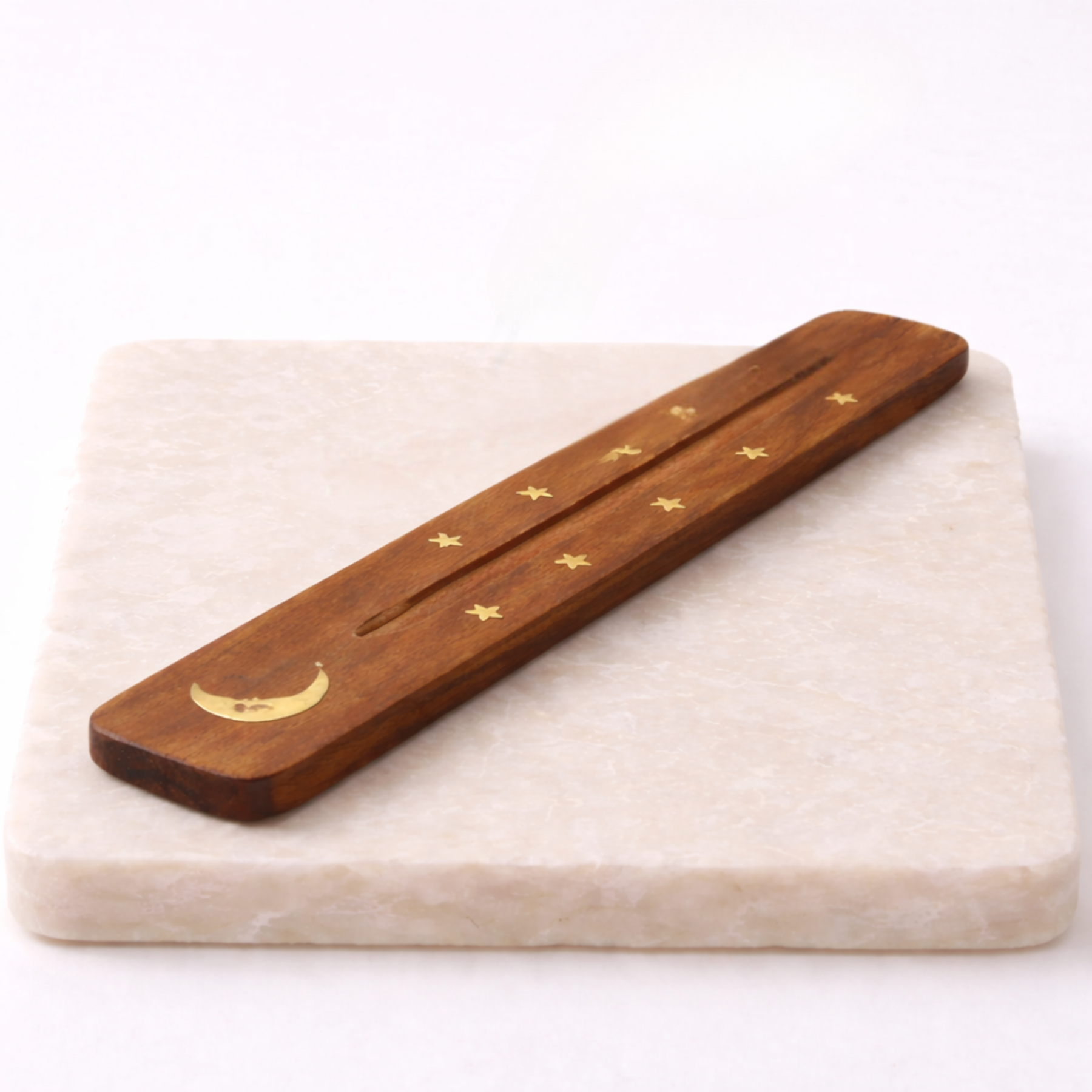 Moon incense holder with incense stick on beige slab side angle