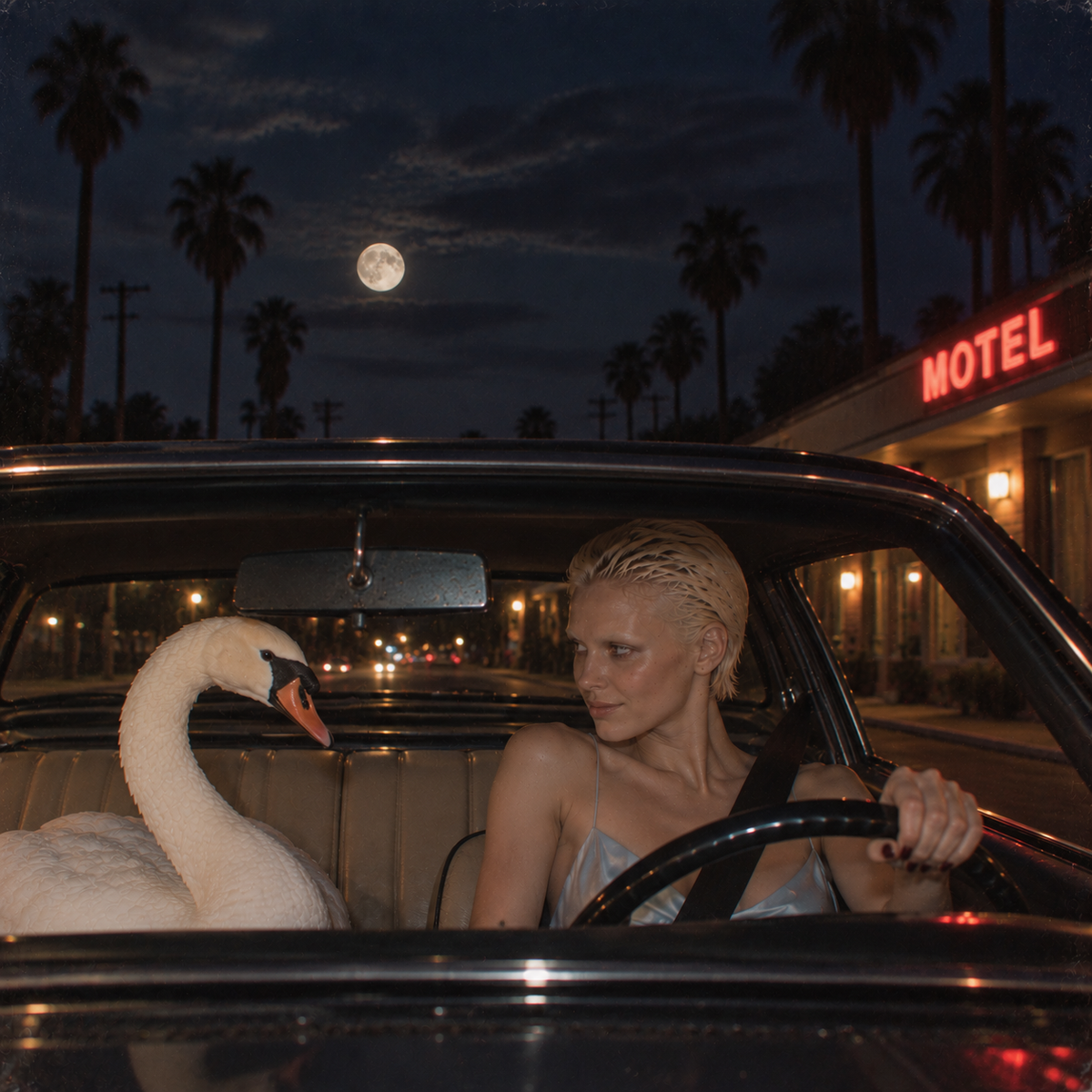 Blonde woman in a pale blue satin dress drives at night with a white swan in the passenger seat beneath a full moon outside a neon motel.