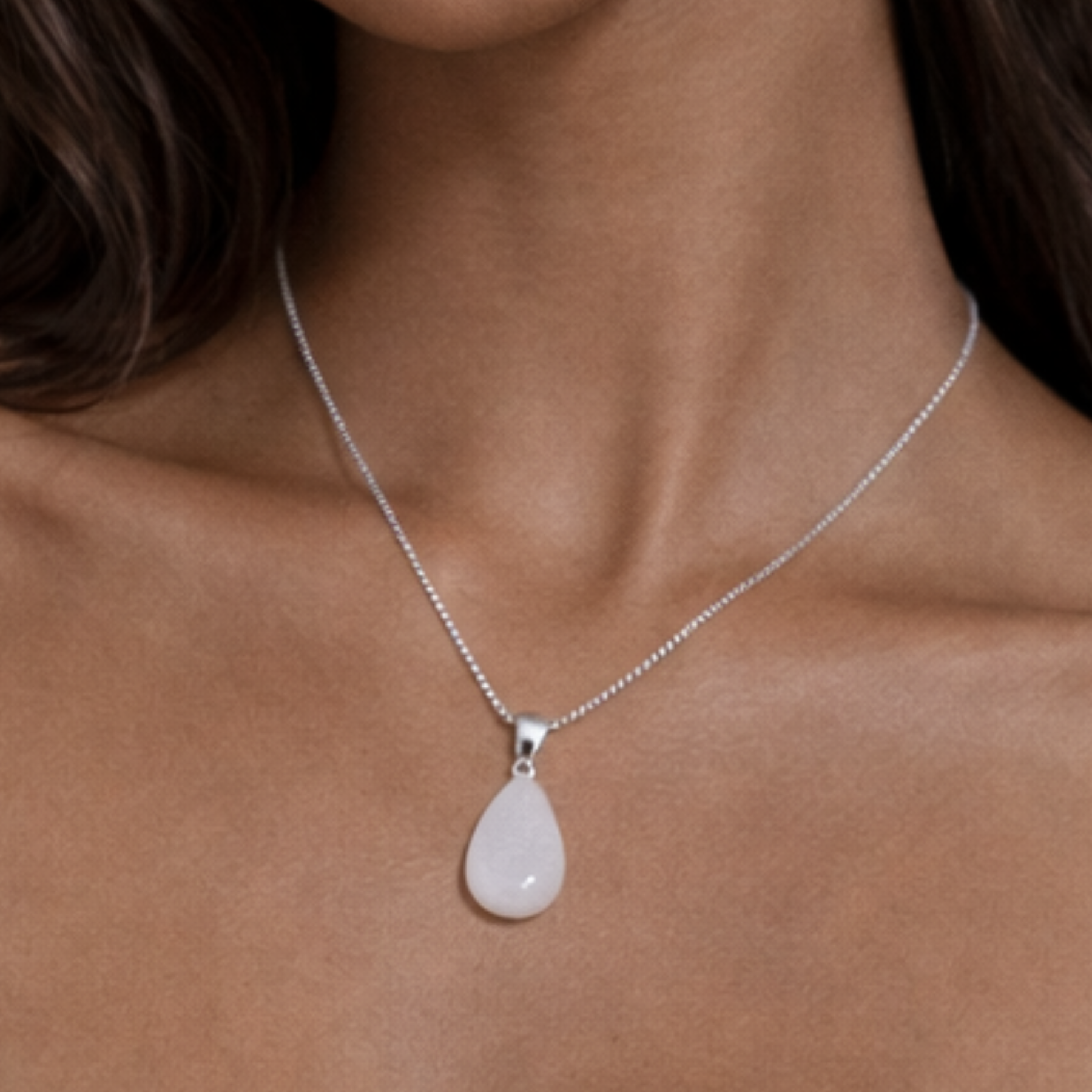 Moonstone necklace close up on model showing teardrop white stone pendant