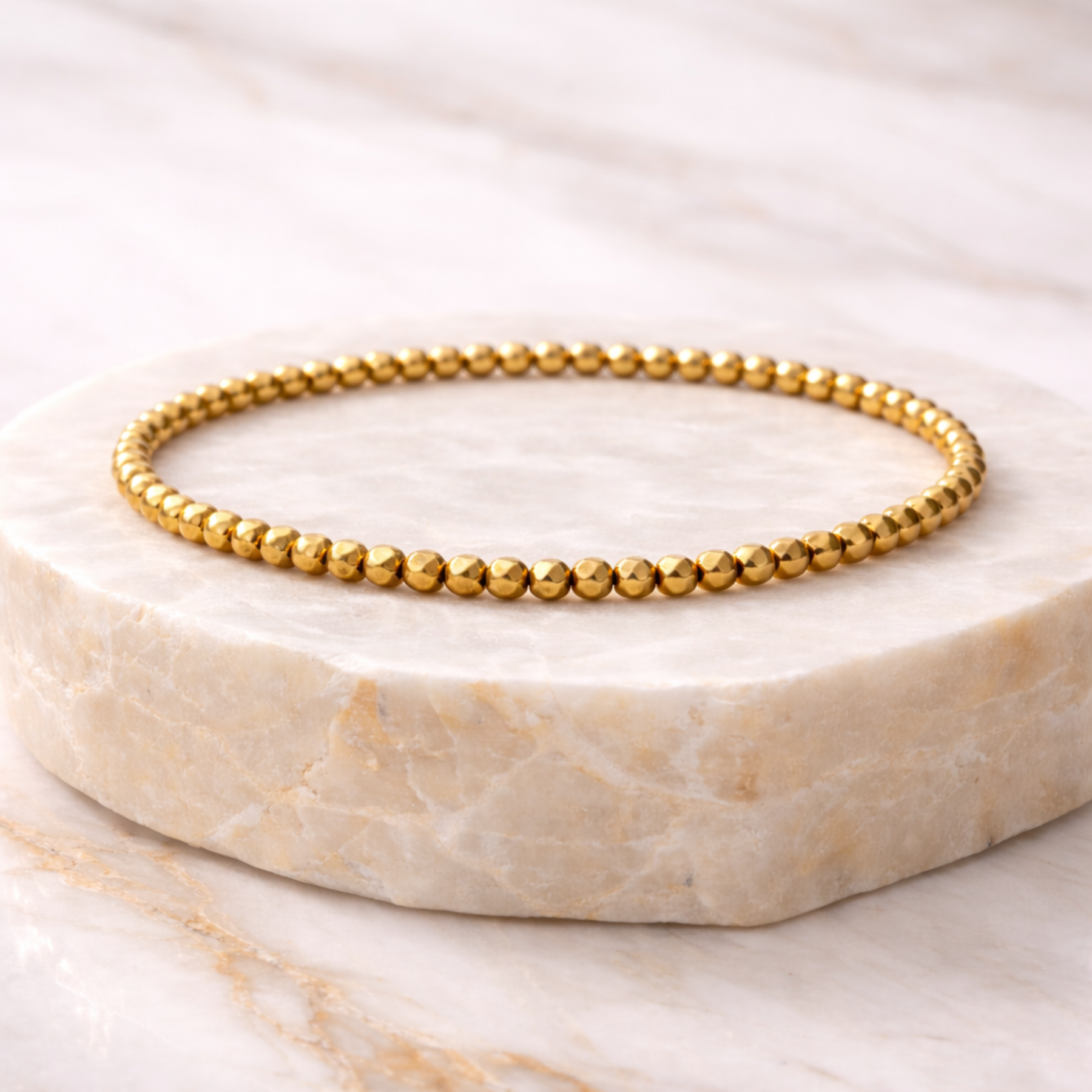 Pyrite faceted bead bracelet on marble display stone