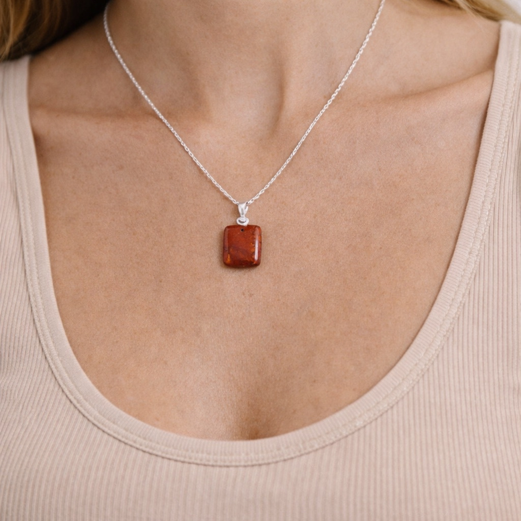 Red jasper necklace close up on model showing square red stone pendant