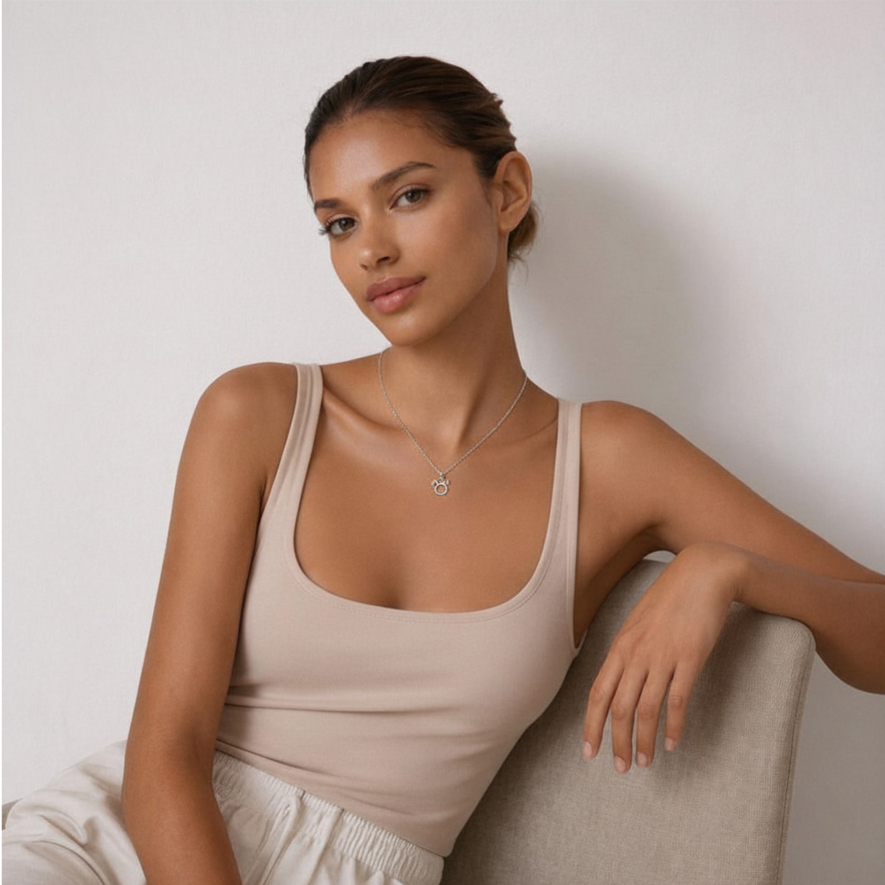 Taurus zodiac necklace silver worn on model sitting down