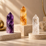 Amethyst, citrine and clear quartz crystal towers displayed on neutral stone plinths in warm natural light.