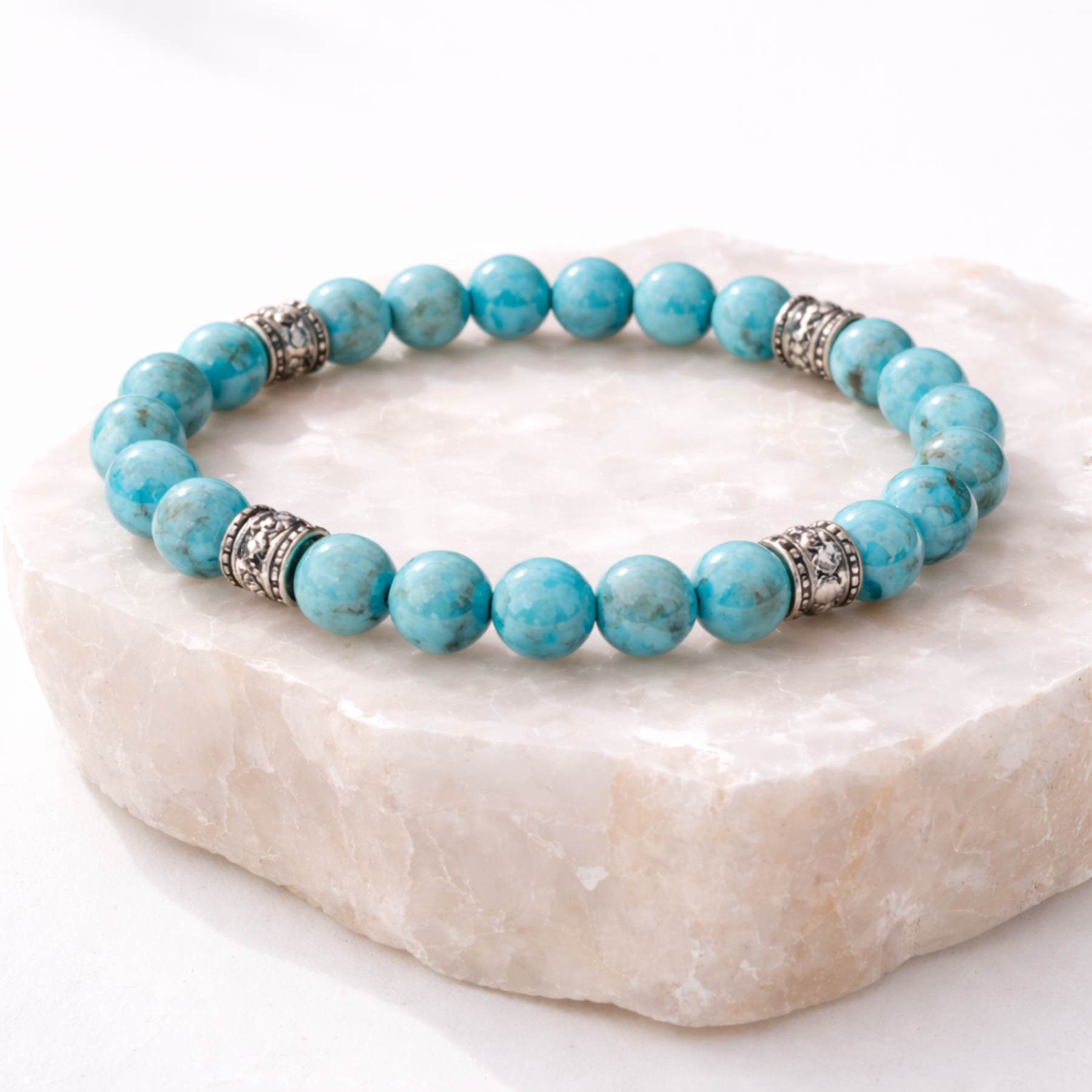 Turquoise bead bracelet with silver spacer beads on stone base