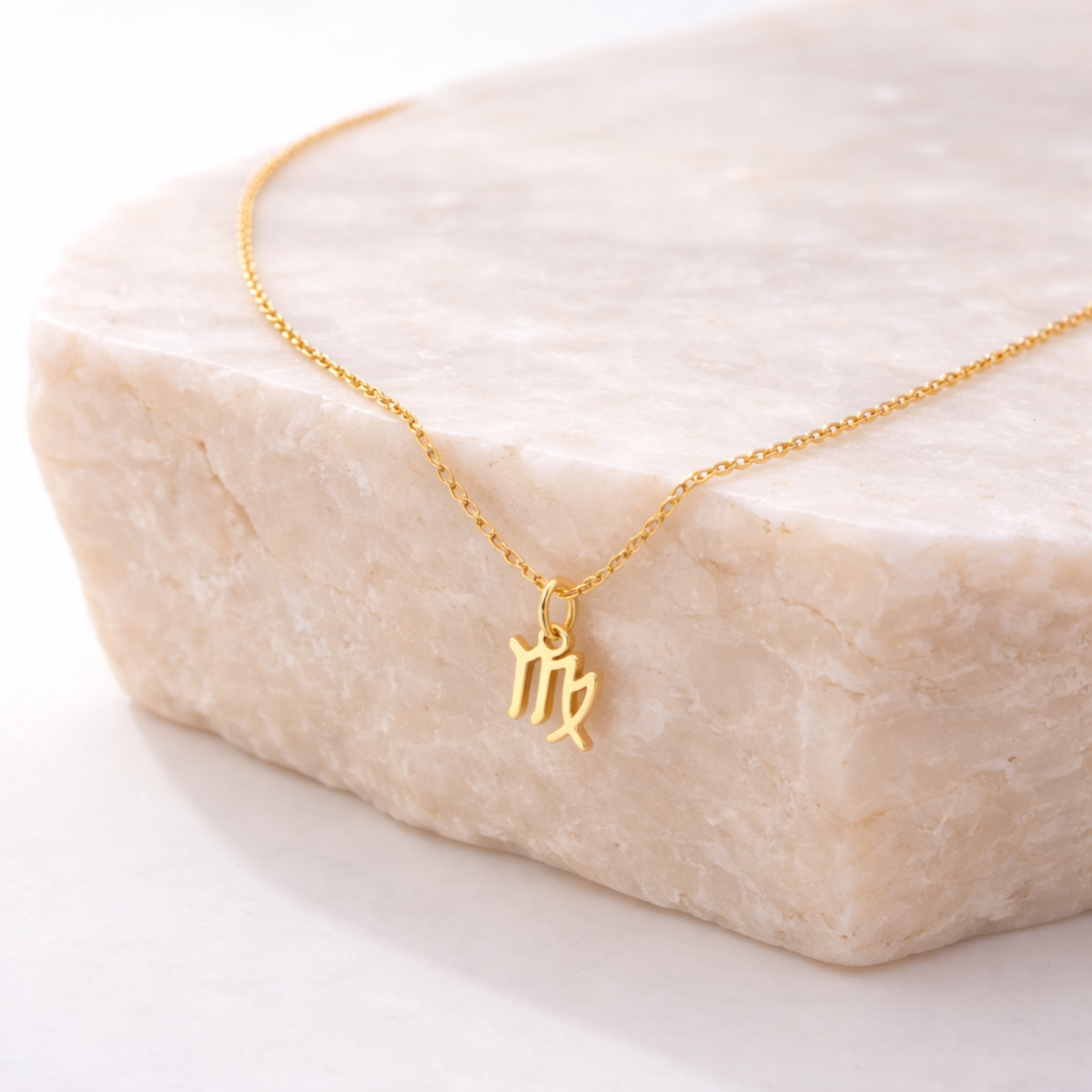Virgo zodiac necklace gold pendant on beige stone slab