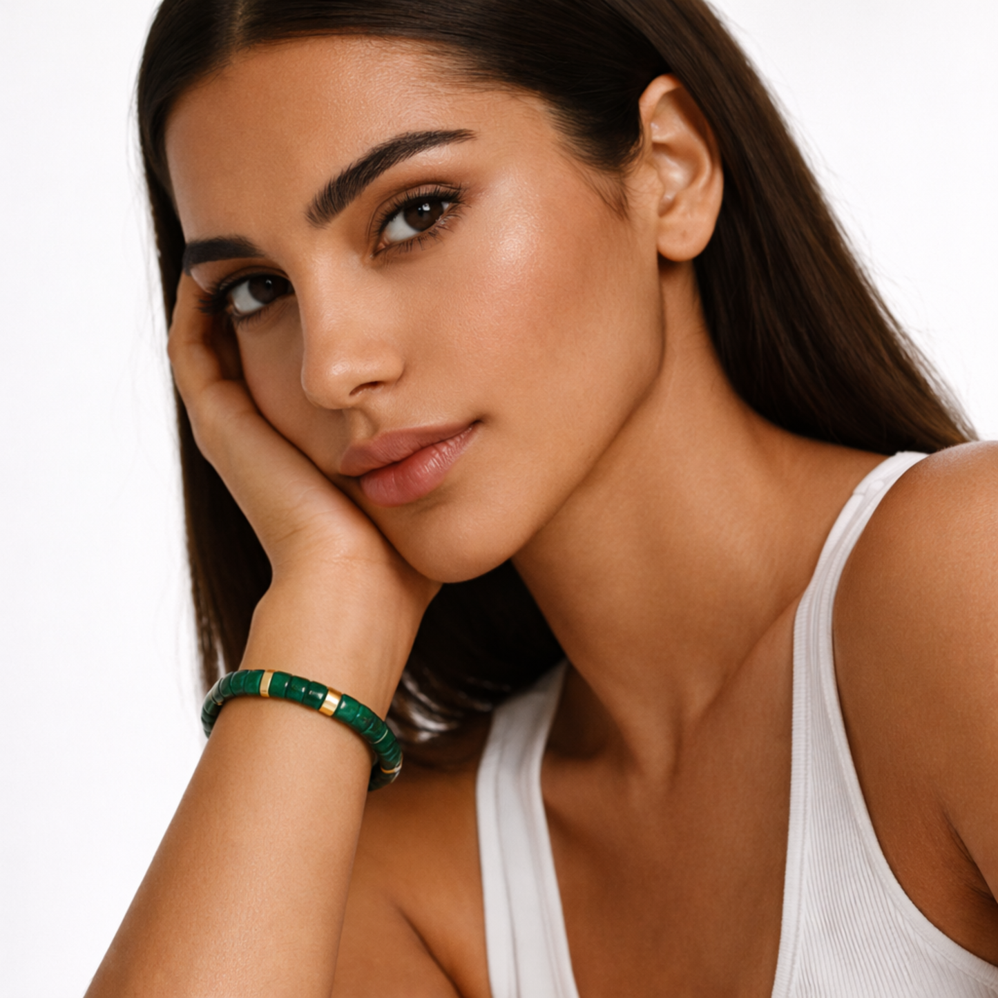 Woman wearing malachite crystal bracelet with green gemstone beads and gold accents